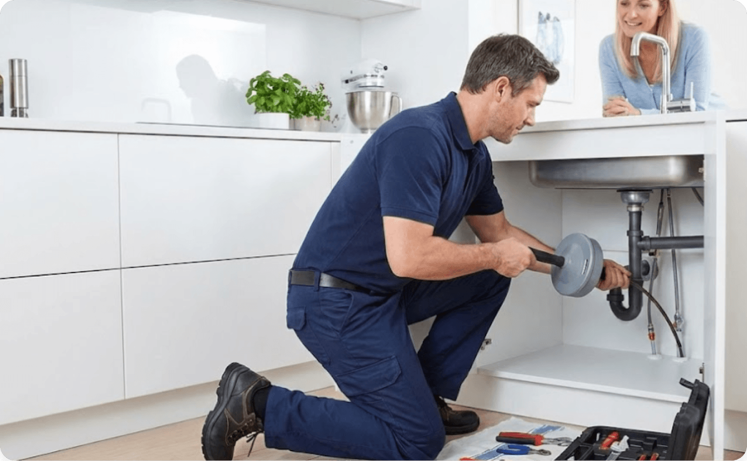 Plumber diagnosing sink drain blockage with inspection tools