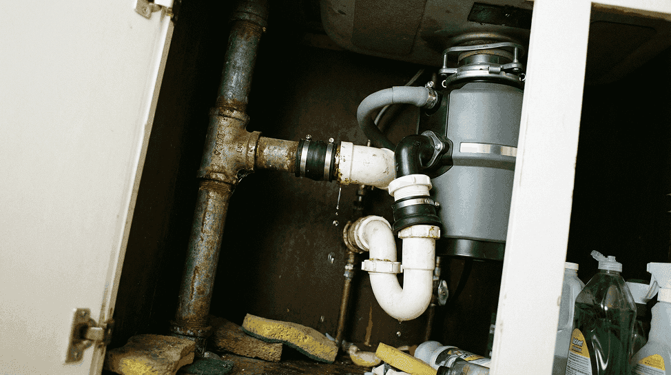 Plumber assessing garbage disposal for repair or replacement in Fresno